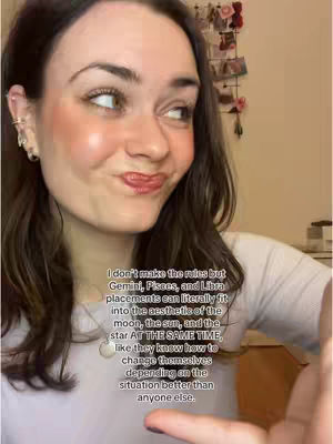 The cover image is a selfie-style shot of a woman. She is positioned slightly off-center, with her head tilted slightly to the side and her gaze towards the upper left. Her hair is dark, and she has light skin with visible blush on her cheeks. She's wearing earrings and a necklace. In the background, a blurred area suggests a room with items such as pictures and a desk. Overlaid on the image is text, which appears towards the bottom right. The overall composition has a casual, friendly tone.