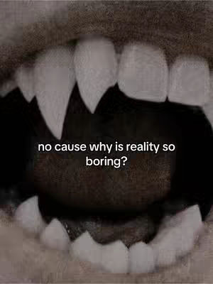 The image shows a close-up of a mouth with stylized vampire fangs. The fangs are long, sharp, and white against a darker background. Above the teeth is a dark gap, and below the teeth is a slightly visible tongue and inner mouth. The image is framed to focus on the teeth and the open mouth. In the center of the image, in white font, is the question: "no cause why is reality so boring?"
