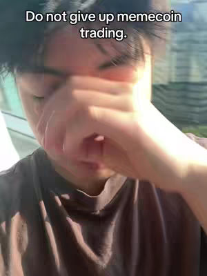 A close-up shot of a young man with dark hair, covering his face with his hand as if in distress or contemplation. The image has a slightly blurred quality, and the background is out of focus, featuring hints of greenery and natural light.