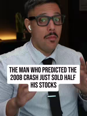 A man with glasses and mustache is speaking on camera. He is wearing a striped button-down shirt and a black tie. Text overlaid on the image reads 'THE MAN WHO PREDICTED THE 2008 CRASH JUST SOLD HALF HIS STOCKS'. The background is blurred but appears to be an office or study setting.