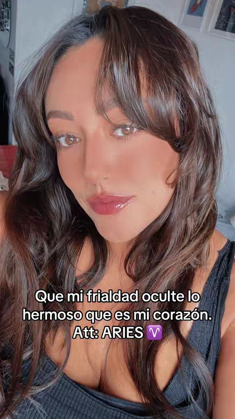 A close-up shot featuring a young woman with dark hair styled with bangs, her gaze directly at the camera with a slightly turned head with dark lips. The text overlay at the bottom is well incorporated into the shot.