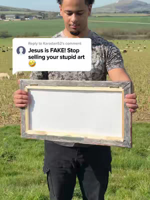 A man stands in a field holding a framed, blank canvas. A speech bubble with text floats near the man, and a green landscape and sky serve as the background.