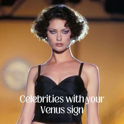 A woman with short, dark, curly hair and dramatic makeup poses in front of a blurred yellow background. She wears a black, strapless top. Text overlayed on the image reads, 'Celebrities with your Venus sign.'