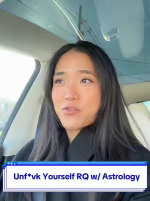 A selfie-style video taken inside a car. The primary subject is a woman with long black hair looking towards the right. She is wearing a black top. The background shows the interior of a car, including the windshield and roof. The video has a text overlay with the words 'Unf*vk Yourself RQ w/ Astrology'.