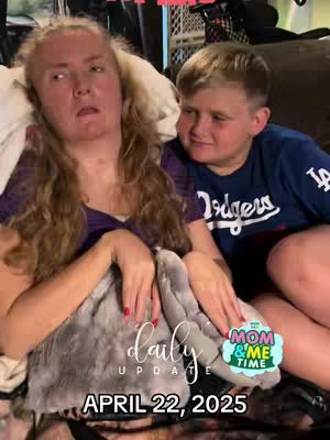 A woman and a young boy share a gentle moment, the woman cradling a stuffed animal while the boy looks at her with affection. Text overlays indicate the video is a 'daily update' and that it is 'Mom & Me Time.'