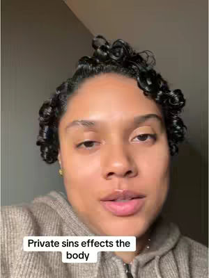 A close-up shot of a woman's face. She has curly hair and is wearing a casual hooded sweatshirt. A text overlay at the bottom says, “Private sins effects the body”.