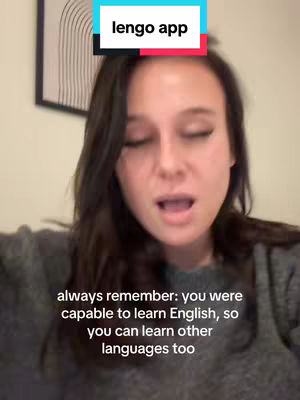 A woman with long brown hair is centered in the shot, her eyes closed while she speaks, and text overlays appear above her head and at the bottom of the frame.