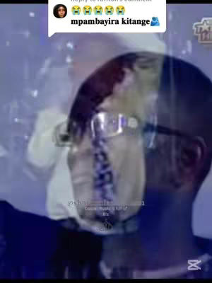 The image shows a person in the foreground, blurred, wearing glasses and a tie, overlayed on a blue-toned background. In the top left corner, there is a comment bubble with a profile picture and text. The comment contains text that appears to be in an African language and some emojis, and there are what appear to be video overlays displaying text.